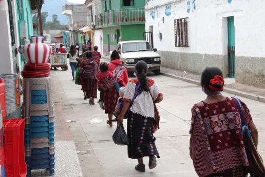 mujeres caminando cargando a su bebé y bolsa de compras
