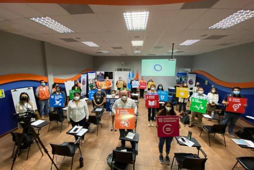 personas sosteniendo carteles de los ODS